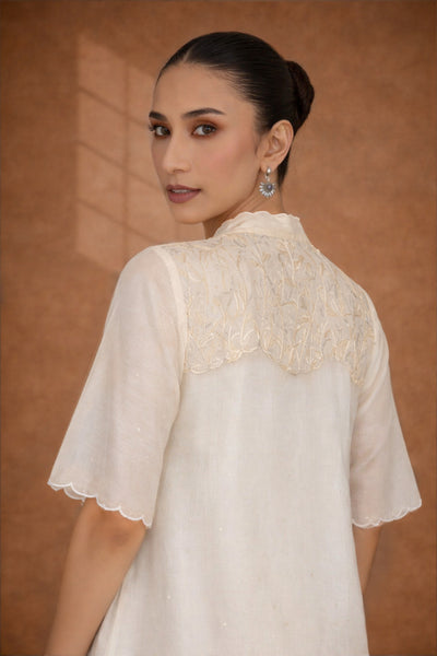 A SOFT IVORY TUNIC WITH DELICATE FLORAL DETAILING FOR EFFORTLESS ELEGANCE