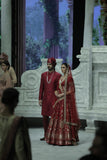 RED BROCADE DOUBLE LAYER LEHENGA PAIRED WITH A RED DUPION EMBROIDERED BLOUSE, RED EMBROIDERED DUPATTA, AND RED EMBROIDERED NET VEIL. (4 PCS)