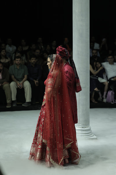 RED BROCADE DOUBLE LAYER LEHENGA PAIRED WITH A RED DUPION EMBROIDERED BLOUSE, RED EMBROIDERED DUPATTA, AND RED EMBROIDERED NET VEIL. (4 PCS)