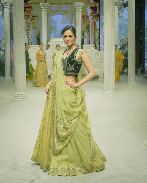 PISTACHIO GREEN EMB LEHENGA SAREE PAIRED WITH A BLACK FLORAL EMB BLOUSE AND EMBELLISHED JACKET.(4 PCS)