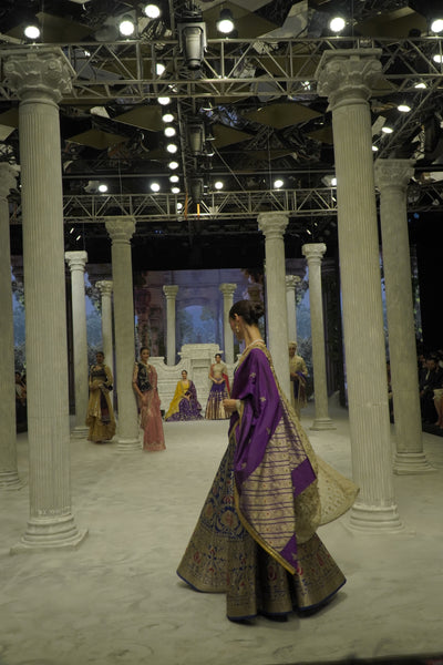 BLUE BROCADE LEHENGA PAIRED WITH A BLUE BUSTIER, PURPLE SILK DUSHALA, AND TOOSH ORGANZA EMBROIDERED DUPATTA.(4PCS)