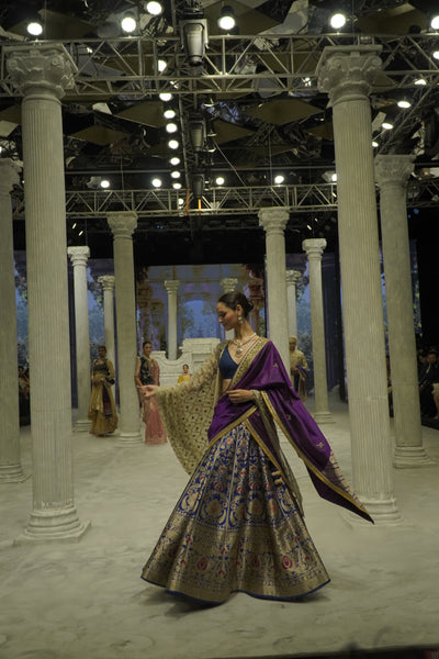 BLUE BROCADE LEHENGA PAIRED WITH A BLUE BUSTIER, PURPLE SILK DUSHALA, AND TOOSH ORGANZA EMBROIDERED DUPATTA.(4PCS)