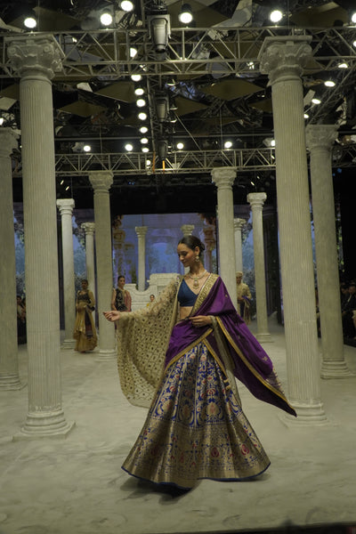 BLUE BROCADE LEHENGA PAIRED WITH A BLUE BUSTIER, PURPLE SILK DUSHALA, AND TOOSH ORGANZA EMBROIDERED DUPATTA.(4PCS)