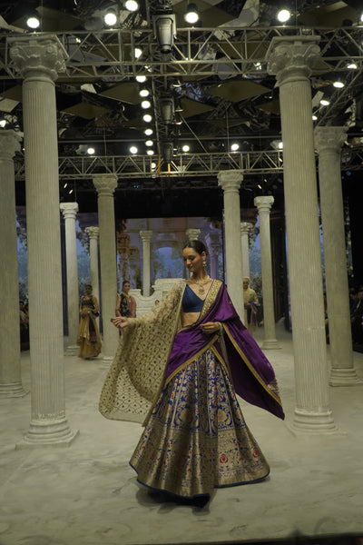 BLUE BROCADE LEHENGA PAIRED WITH A BLUE BUSTIER, PURPLE SILK DUSHALA, AND TOOSH ORGANZA EMBROIDERED DUPATTA.(4PCS)