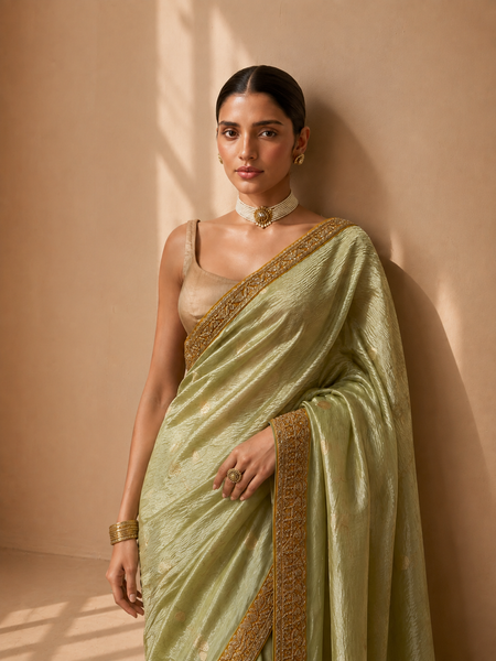 A SOFT PASTEL GREEN SAREE WITH A DETAILED GOLD BORDER. (2PCS)