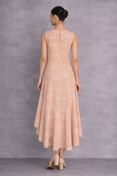 A SOFT PEACH SLEEVELESS DRESS DEFINED BY FLUID MOVEMENTAND SUBTLE GRACE