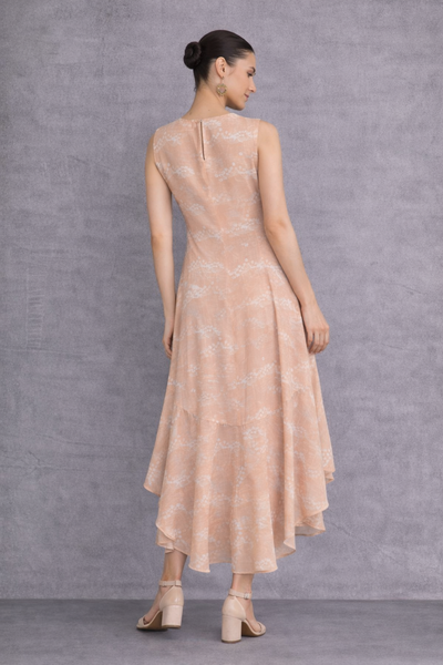 A SOFT PEACH SLEEVELESS DRESS DEFINED BY FLUID MOVEMENTAND SUBTLE GRACE