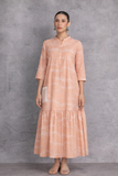 A SOFT PEACH DRESS WITH A FLUID, TIERED SILHOUETTE AND UNDERSTATED GRACE
