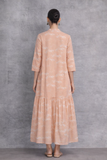 A SOFT PEACH DRESS WITH A FLUID, TIERED SILHOUETTE AND UNDERSTATED GRACE