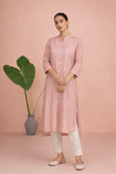 A PEACH TUNIC SHAPED IN FLUID EASE AND UNDERSTATED REFINEMENT