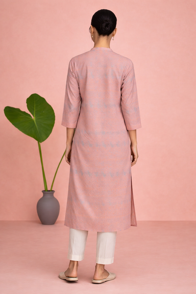 A PEACH TUNIC SHAPED IN FLUID EASE AND UNDERSTATED REFINEMENT