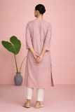 A PEACH TUNIC SHAPED IN FLUID EASE AND UNDERSTATED REFINEMENT