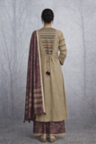 A LINEN JACKET LAYERED OVER A BROWN TUSSAR SAREE, BLENDING STRUCTURE WITH SOFT DRAPE.