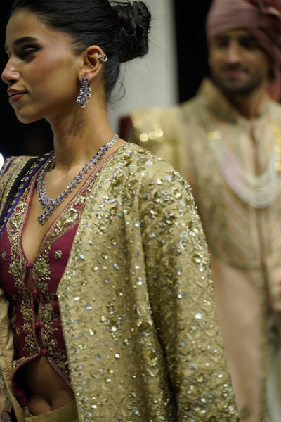GOLD DRAPE SKIRT PAIRED WITH A RUBY EMBROIDERED KOTI, GOLD TISSUE EMBROIDERED LONG JACKET, AND PURPLE ANTIQUE DUPATTA. (4 PCS)