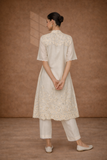 A SOFT IVORY TUNIC WITH DELICATE FLORAL DETAILING FOR EFFORTLESS ELEGANCE