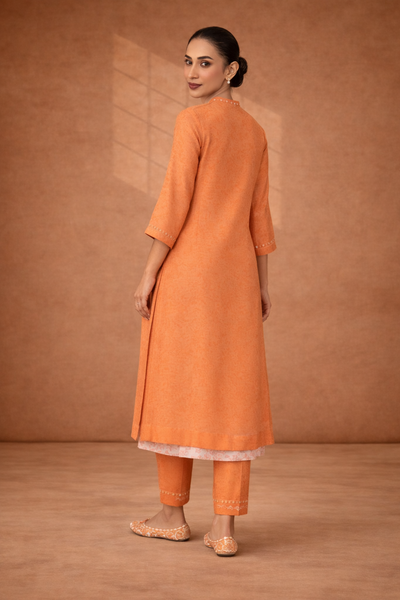 A SOFT ORANGE KOTA SET WITH DELICATE DETAILING FOR EFFORTLESS DAY ELEGANCE