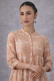 A SOFT PEACH PRINTED TUNIC WITH A FLUID , FLARED SILHOUETTE AND UNDERSTATED ELEGANCE