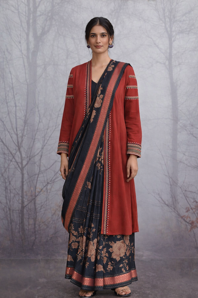 A MADDER RED LINEN JACKET PAIRED WITH A BLACK TUSSAR SILK SAREE.
