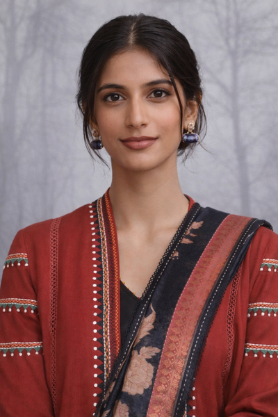 A MADDER RED LINEN JACKET PAIRED WITH A BLACK TUSSAR SILK SAREE.