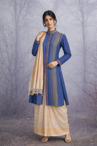 A BLUE COTTON HANDLOOM JACKET PAIRED WITH A BEIGE TUSSAR SILK SAREE.