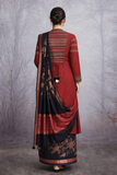A MADDER RED LINEN JACKET PAIRED WITH A BLACK TUSSAR SILK SAREE.