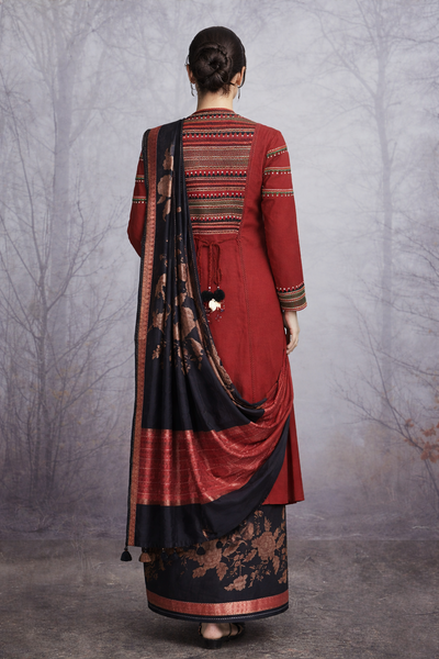 A MADDER RED LINEN JACKET PAIRED WITH A BLACK TUSSAR SILK SAREE.