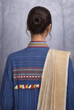 A BLUE COTTON HANDLOOM JACKET PAIRED WITH A BEIGE TUSSAR SILK SAREE.