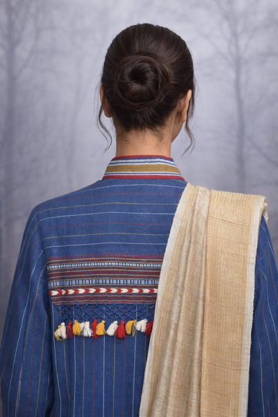 A BLUE COTTON HANDLOOM JACKET PAIRED WITH A BEIGE TUSSAR SILK SAREE.