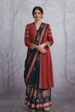 A MADDER RED LINEN JACKET PAIRED WITH A BLACK TUSSAR SILK SAREE.
