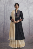A BLACK EMBROIDERED VISCOSE DUPION JACKET PAIRED WITH A BEIGE TUSSAR SILK SAREE.