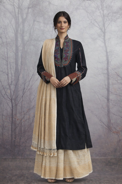A BLACK EMBROIDERED VISCOSE DUPION JACKET PAIRED WITH A BEIGE TUSSAR SILK SAREE.