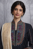 A BLACK EMBROIDERED VISCOSE DUPION JACKET PAIRED WITH A BEIGE TUSSAR SILK SAREE.