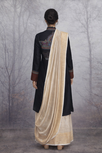 A BLACK EMBROIDERED VISCOSE DUPION JACKET PAIRED WITH A BEIGE TUSSAR SILK SAREE.