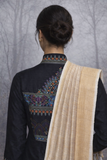 A BLACK EMBROIDERED VISCOSE DUPION JACKET PAIRED WITH A BEIGE TUSSAR SILK SAREE.