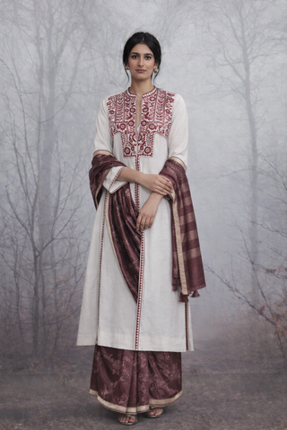 AN EMBROIDERED LINEN JACKET STYLED WITH A BROWN TUSSAR SAREE FOR A QUIETLY STRIKING LOOK.