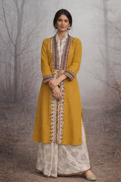 A MUSTARD LINEN JACKET PAIRED WITH A BEIGE TUSSAR SAREE, CRAFTED FOR QUIET IMPACT.