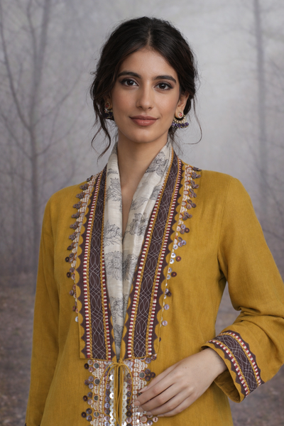 A MUSTARD LINEN JACKET PAIRED WITH A BEIGE TUSSAR SAREE, CRAFTED FOR QUIET IMPACT.