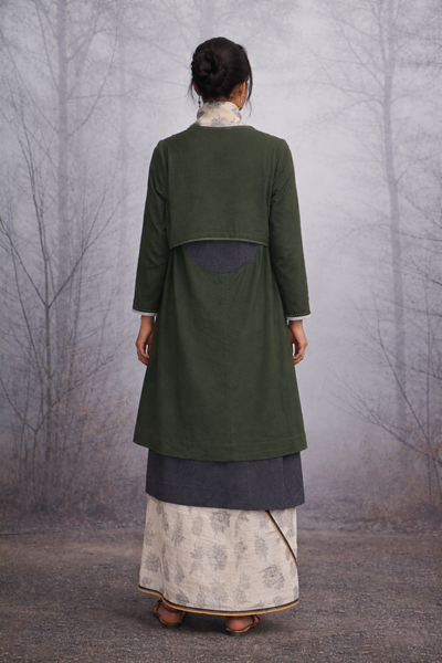 A CHECK JACKET LAYERED OVER A PRINTED SAREE FOR EFFORTLESS BALANCE.