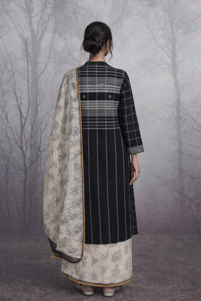 A LINEN JACKET LAYERED OVER A SOFTLY DRAPED TUSSAR SAREE.