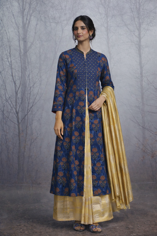 A STRUCTURED BLUE JACKET WITH A SOFT SILK TISSUE SAREE, BALANCED IN CONTRAST AND EASE.