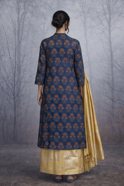 A STRUCTURED BLUE JACKET WITH A SOFT SILK TISSUE SAREE, BALANCED IN CONTRAST AND EASE.