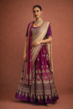 A DEEP PURPLE LEHENGA PAIRED WITH A MATCHING EMBROIDERED BLOUSE AND A CONTRAST GREEN AND PURPLE DUPATTA. (KS-15)