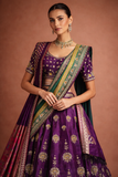 A REGAL PURPLE LEHENGA WITH A CONTRAST GREEN AND PURPLE DUPATTA.