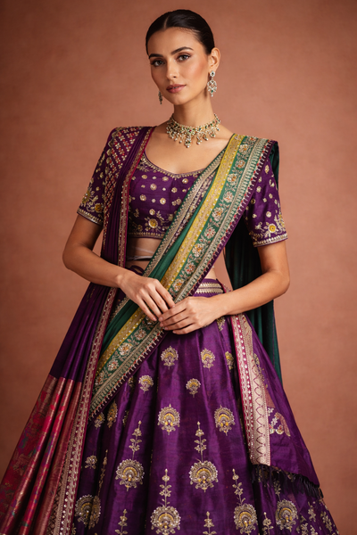 A REGAL PURPLE LEHENGA WITH A CONTRAST GREEN AND PURPLE DUPATTA.
