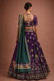 A REGAL PURPLE LEHENGA WITH A CONTRAST GREEN AND PURPLE DUPATTA.