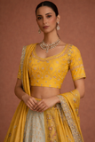A YELLOW LEHENGA PAIRED WITH A MATCHING EMBROIDERED BLOUSE AND A SOFT POWDER BLUE PANEL WITH DUPATTA.(KA-01B)