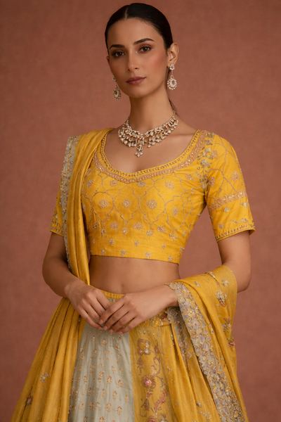 A YELLOW LEHENGA PAIRED WITH A MATCHING EMBROIDERED BLOUSE AND A SOFT POWDER BLUE PANEL WITH DUPATTA.(KA-01B)