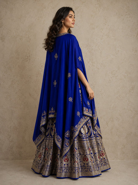 ROYAL BLUE LEHENGA SET FEATURING INTRICATE FLORAL WEAVES AND ELEGANT SILVER-TONED DETAILS.