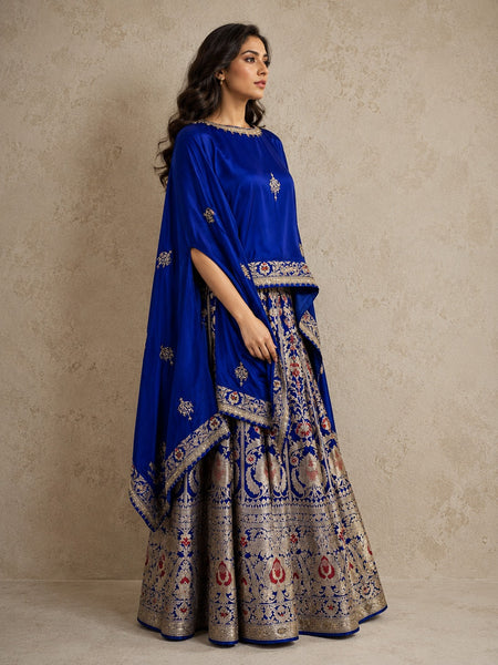 ROYAL BLUE LEHENGA SET FEATURING INTRICATE FLORAL WEAVES AND ELEGANT SILVER-TONED DETAILS.