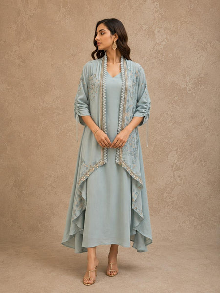 POWDER BLUE INNER DRESS PAIRED WITH AN EMBROIDERED CAPE JACKET FOR AN EFFORTLESSLY ELEGANT LOOK.